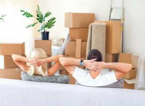 A couple sitting on a sofa after a successful move